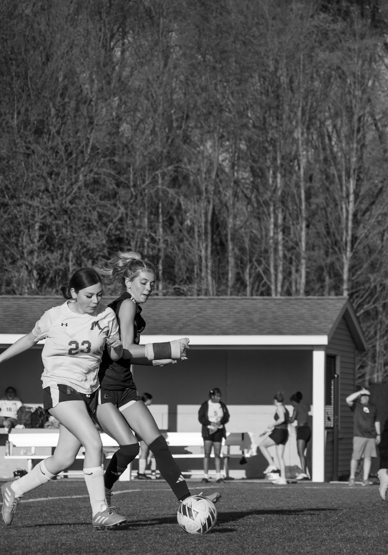 Maya Terryn battles for the ball, reaching around her defender while refusing to be pushed off possession. (Photo by Aibree Akers)
