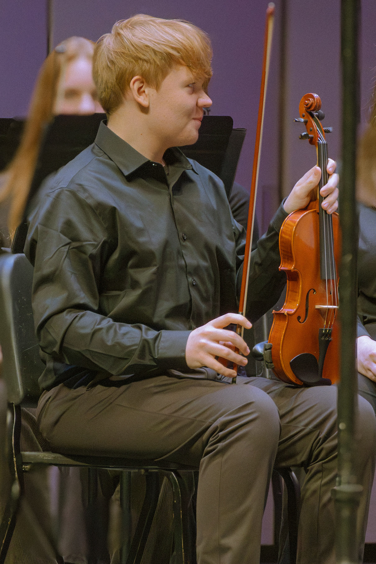 Sophomore Noah Soper prepares to perform after tuning his violin in the orchestra concert.(Photo by Ollie Fox)