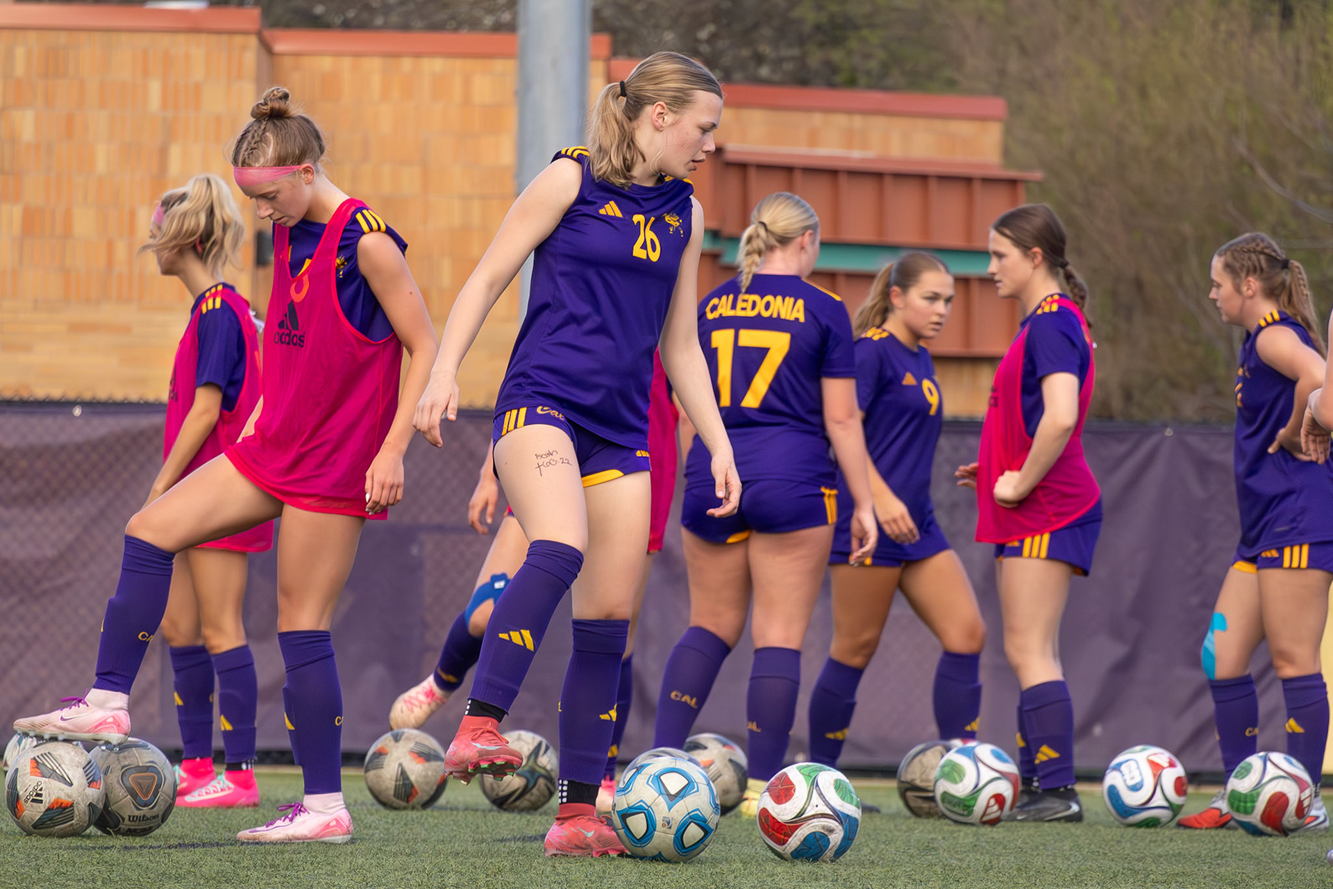 Ellie VanderRoest warms up before the game, rolling the ball between her feet alongside her teammates. (Photo by Ava LaBine)