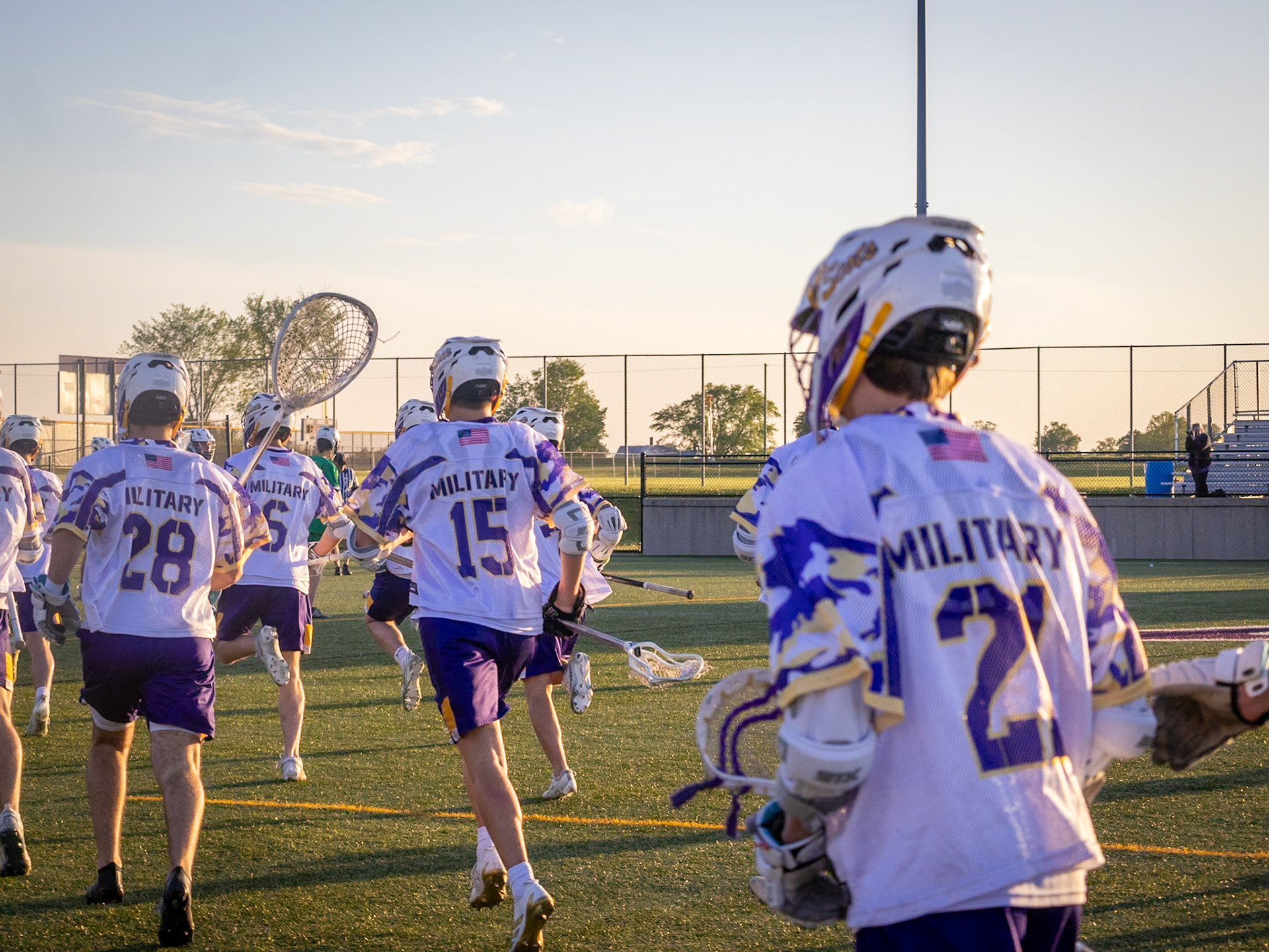 The varsity boys lacrosse team celebrates with its goalie after a win over Saginaw Heritage, improving to 12–3 on the season. (Photo by Lilli Jackson)