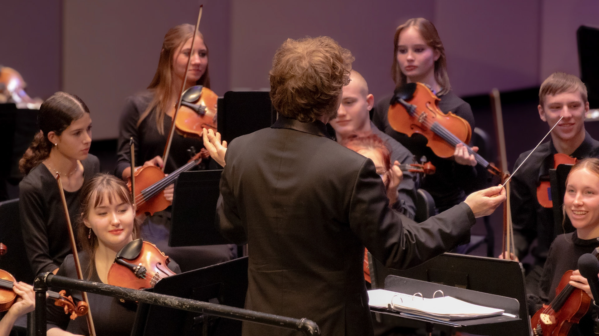 Orchestra Director Mr. Liker prepares to lead the audience as the orchestra begins their performance.
