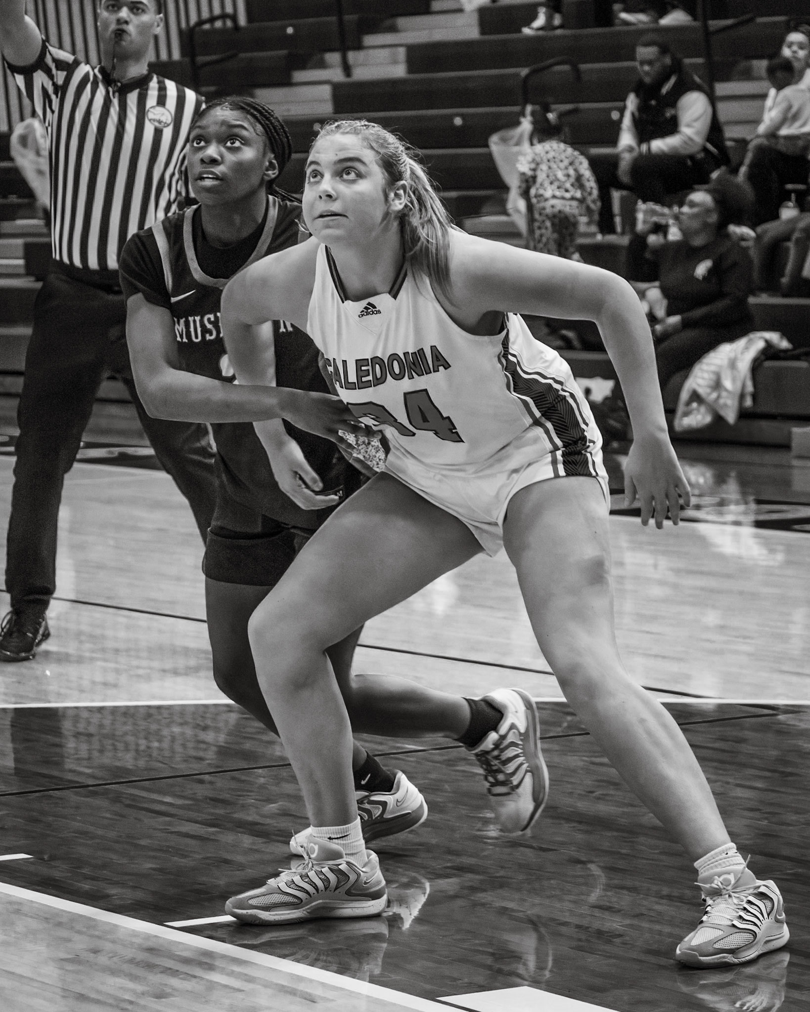 REBOUND BATTLE Mallory Graham holds position against a Muskegon player as she anticipates the rebound. (Photo by Taya Penoes)