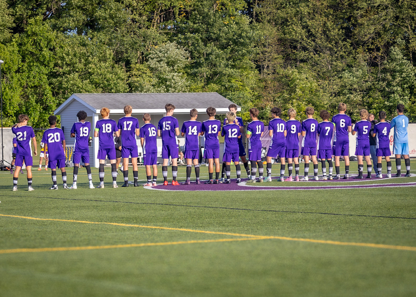 The players share a high five as they line up before the game. (Photo by Brianne Weih)