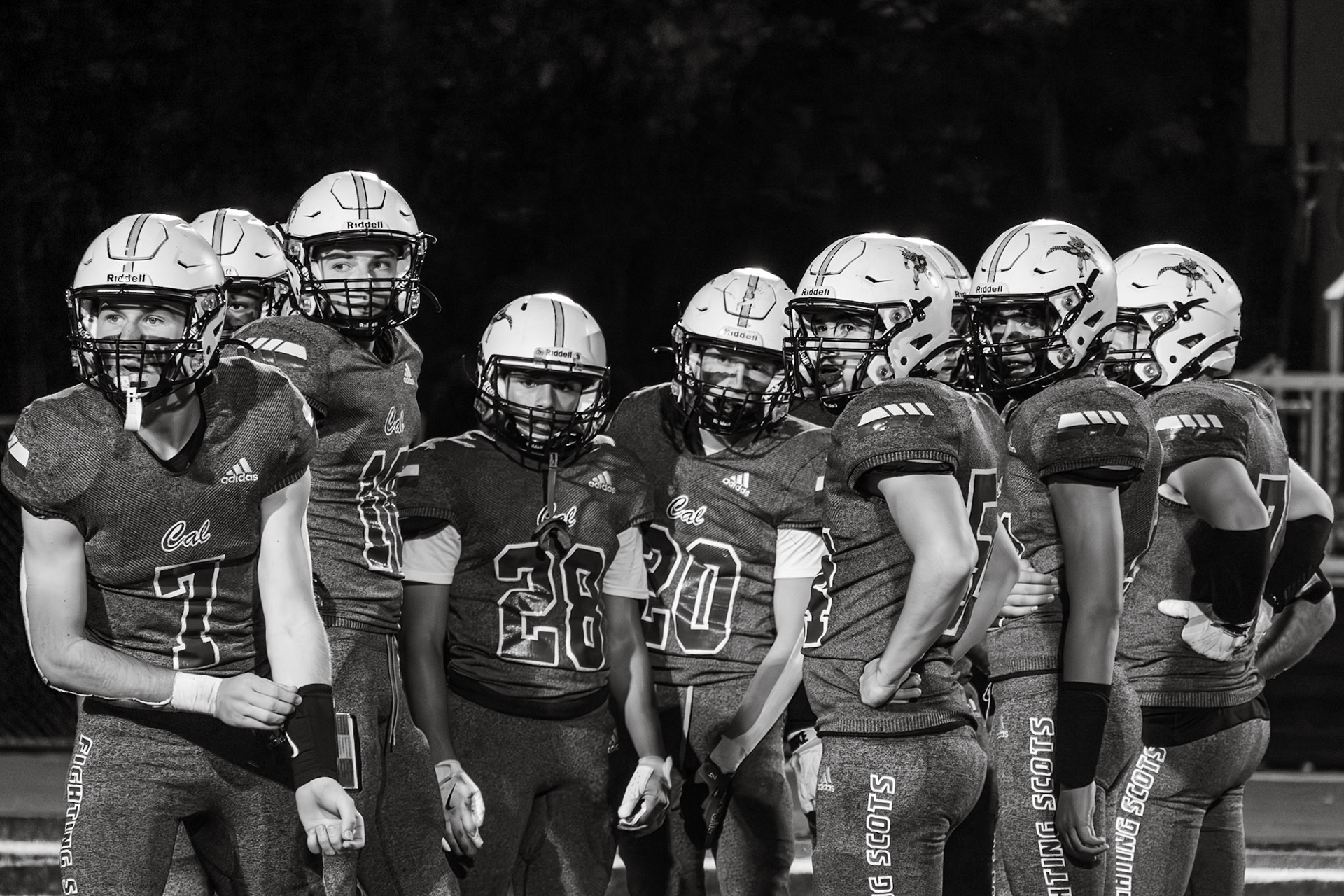 The JV football players look to their coach for the next play. When asked about the team’s unity, Miles Doos says, "It’s like we are one big family.” (Photo by Sydney Palmer)