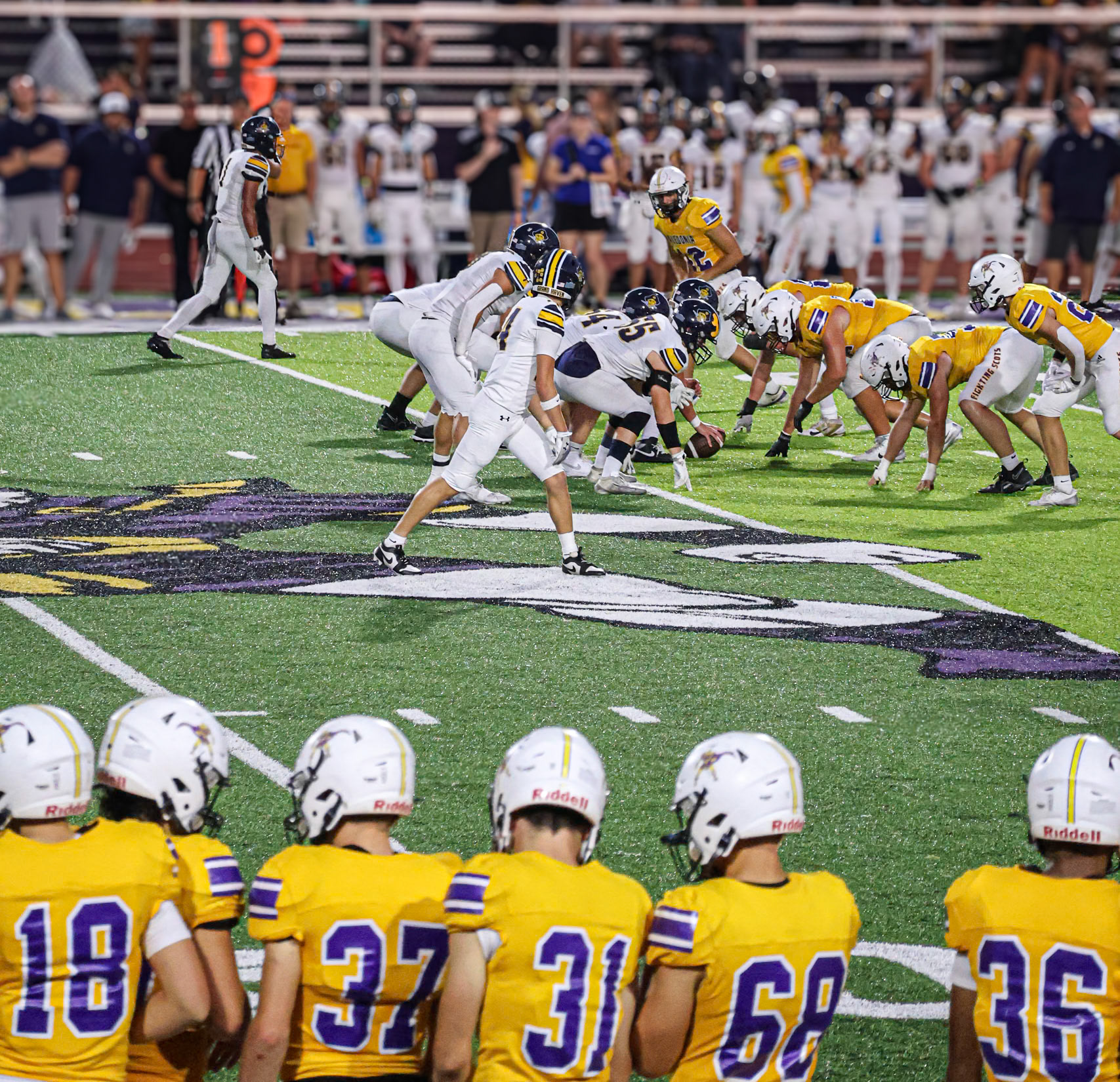 The varsity defense focuses on Grand Haven as they prepare for the snap during this Homecoming showdown. (Photo By Brianna Severson)