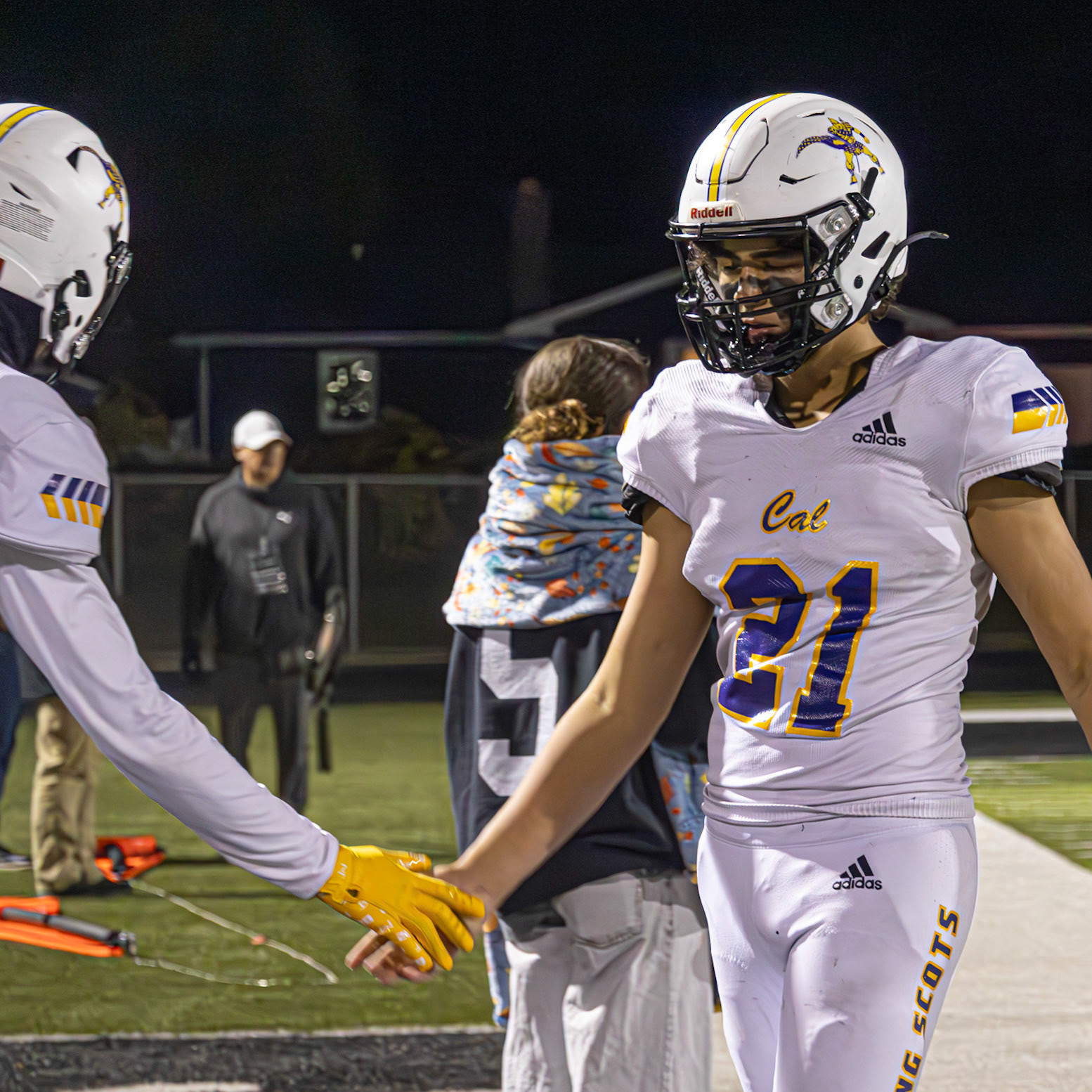 After an amazing stop, Caledonia linebacker Jackson Heffner walks off the field with confidence, receiving high fives from teammates on the sidelines. (Photo by Ella-Grace Wickens)