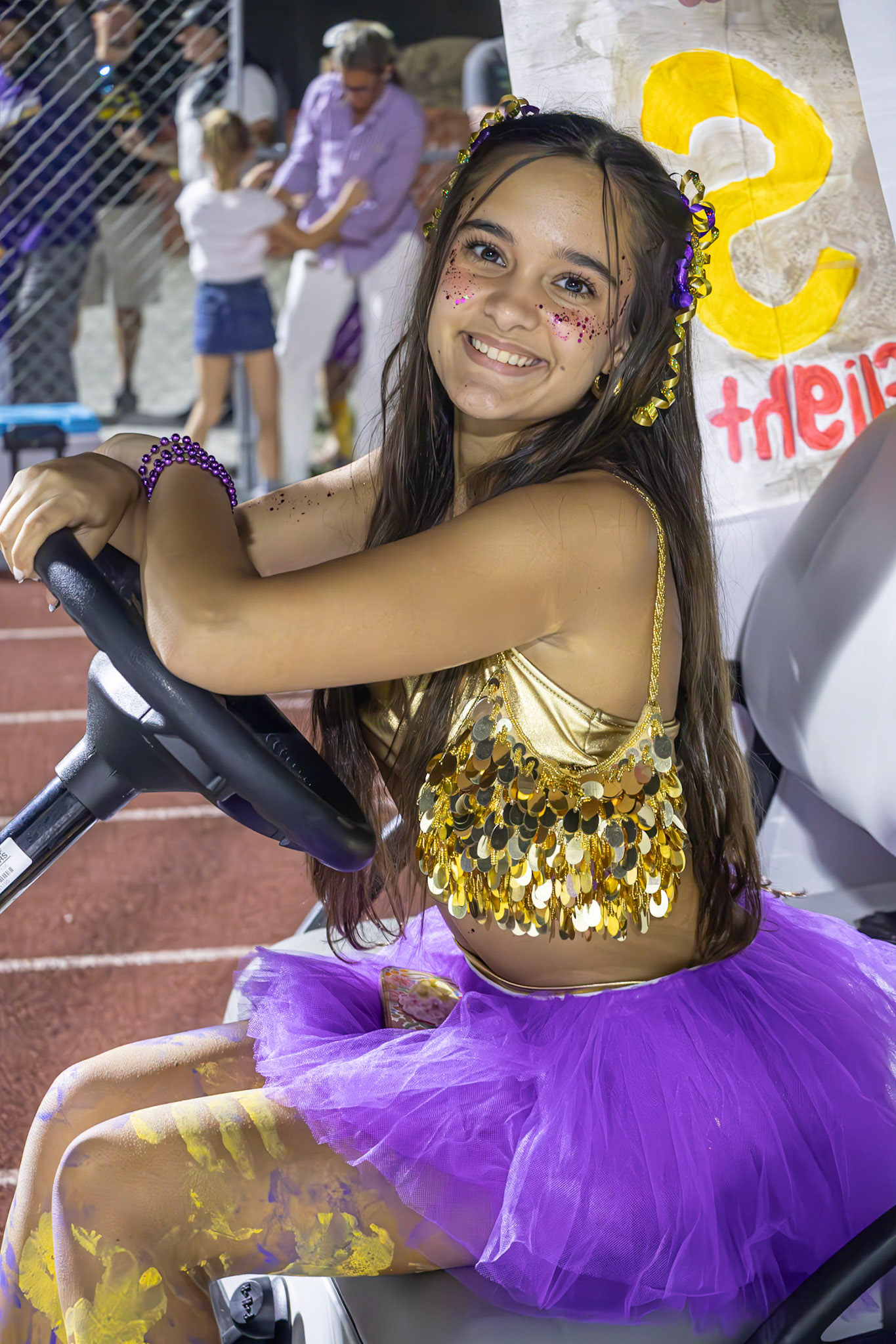 Maya White drives the golf cart, leading the Homecoming floats down the track. (Photo by Taya Penoes)