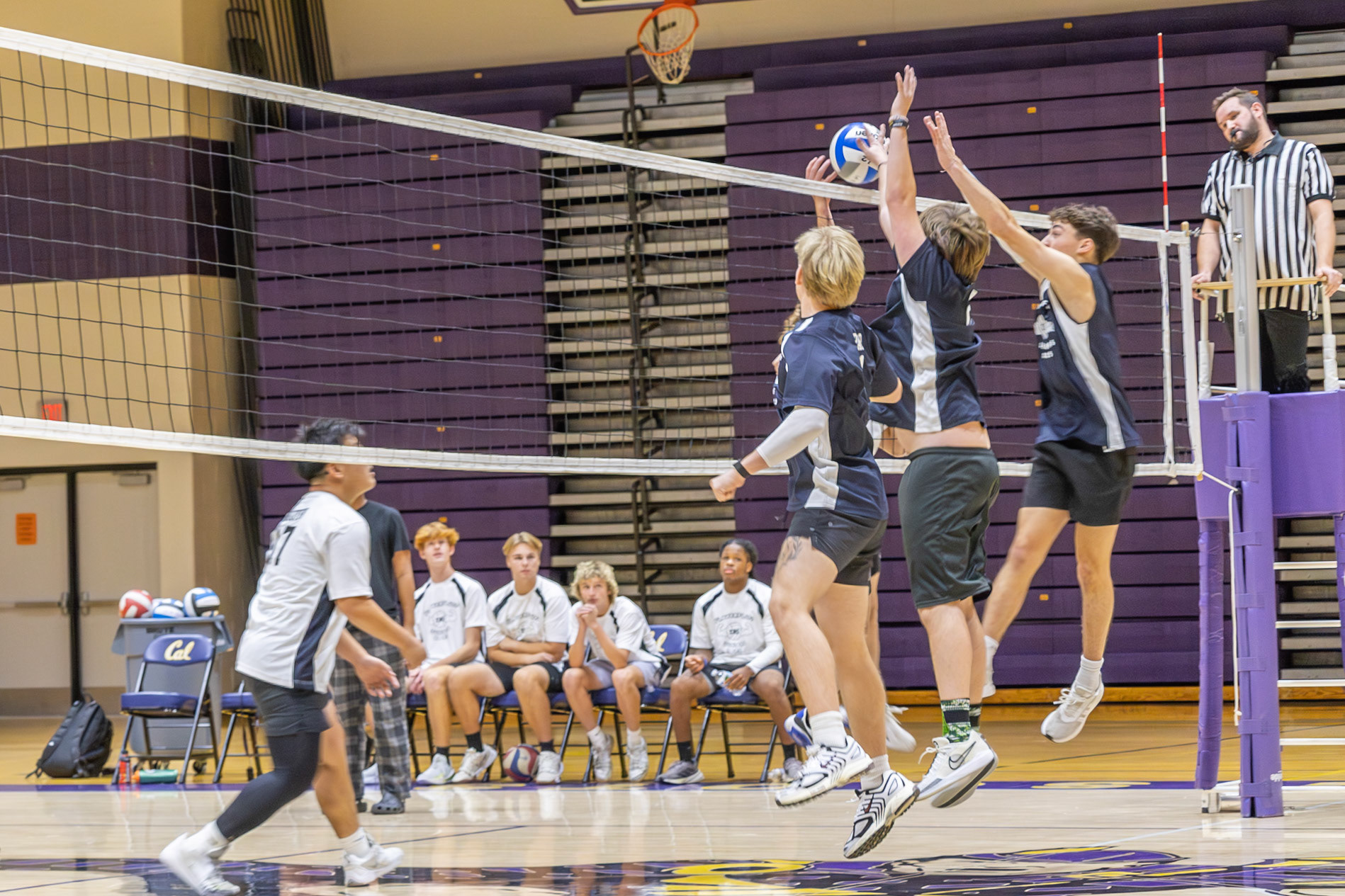 Jameson Palmer, Colter Haywood, and Jaren King rush the net to block a hit from junior Chase Geister. (Photo by Rhyan Guzman)