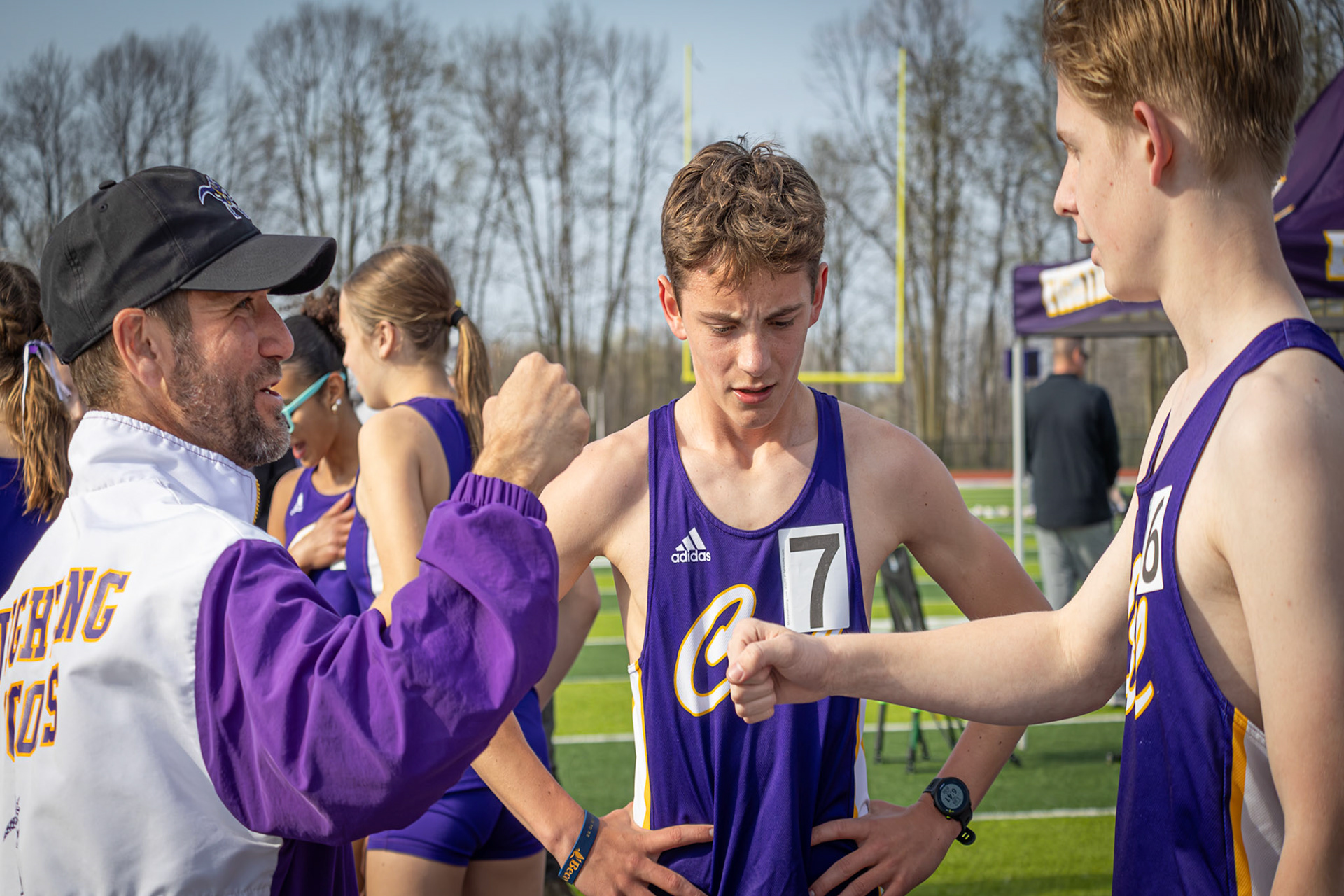 After a running the 1600 meter race , Coach Thompson is overjoyed for Holden Ahee and Levi VanderLaan. (Photo by Emma Garza)