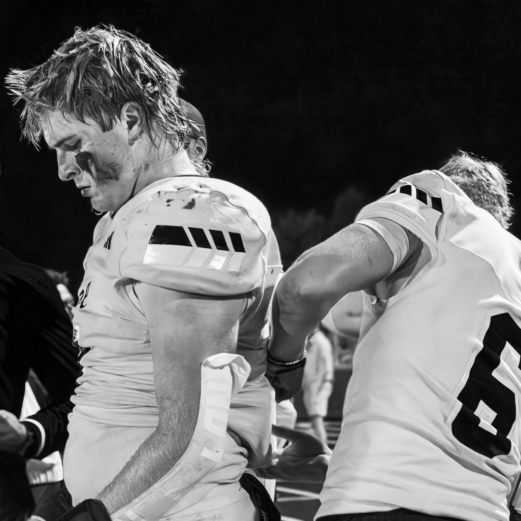 A quick fix from Chase Whisler helps Elliot Clark get game-ready and focused for the next play against Hudsonville. (Photo by Lillian Jackson)