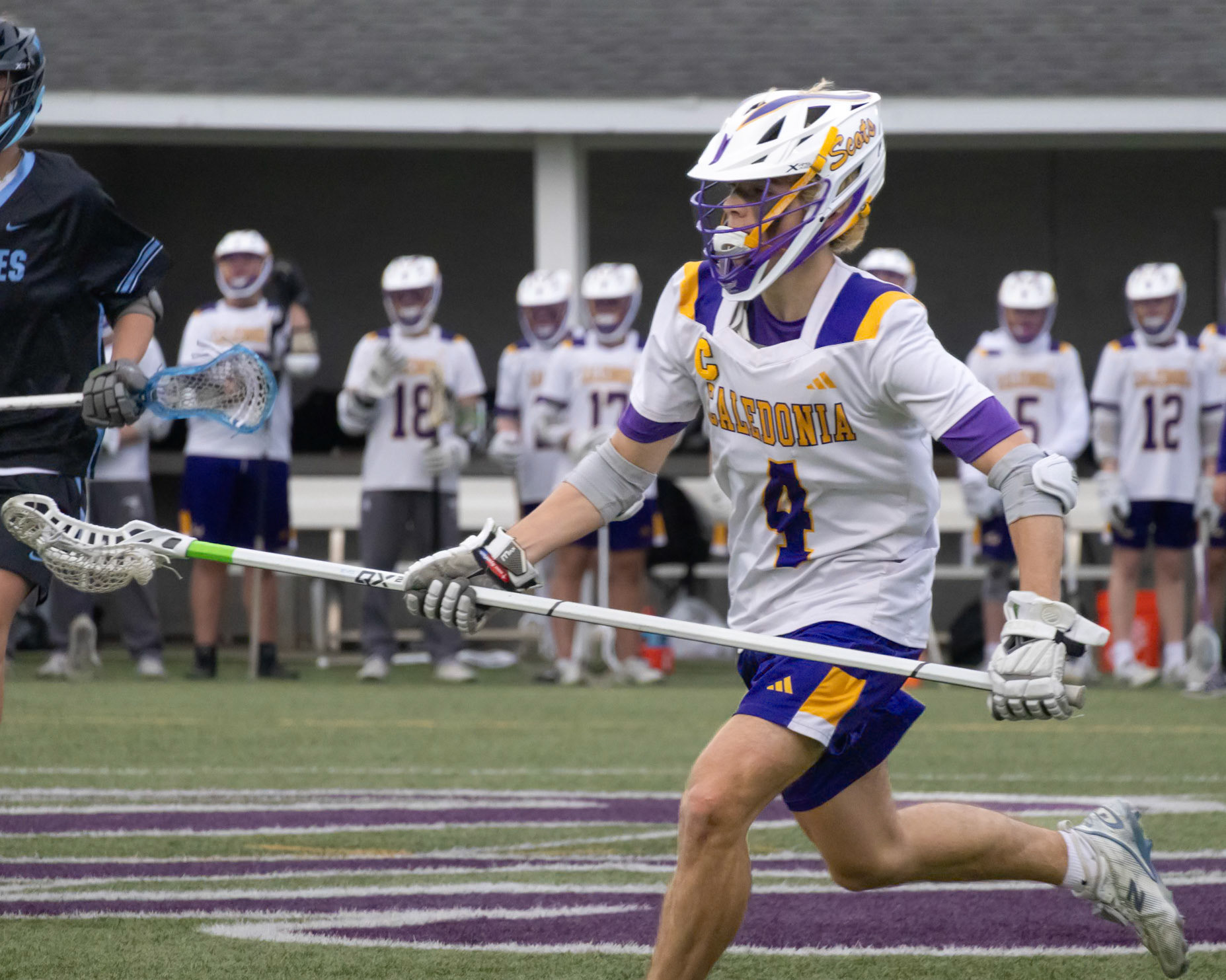 (43) Sam Hoag spins past a Forest Hills Northern defender and moves the ball upfield to the offense. (Photo by Ella-Grace Wickens)