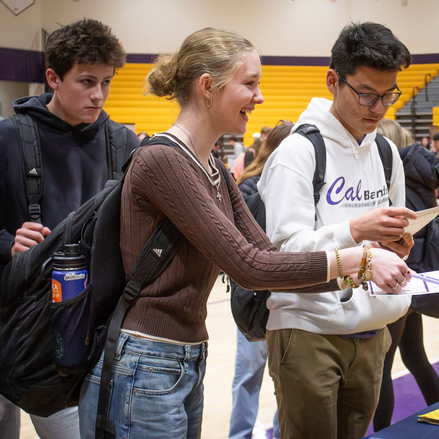 Savannah Robinson hands her bingo card to a Michigan representative for a signature, checking off another square at the college fair. (Photo by Mya VanderZwaag)