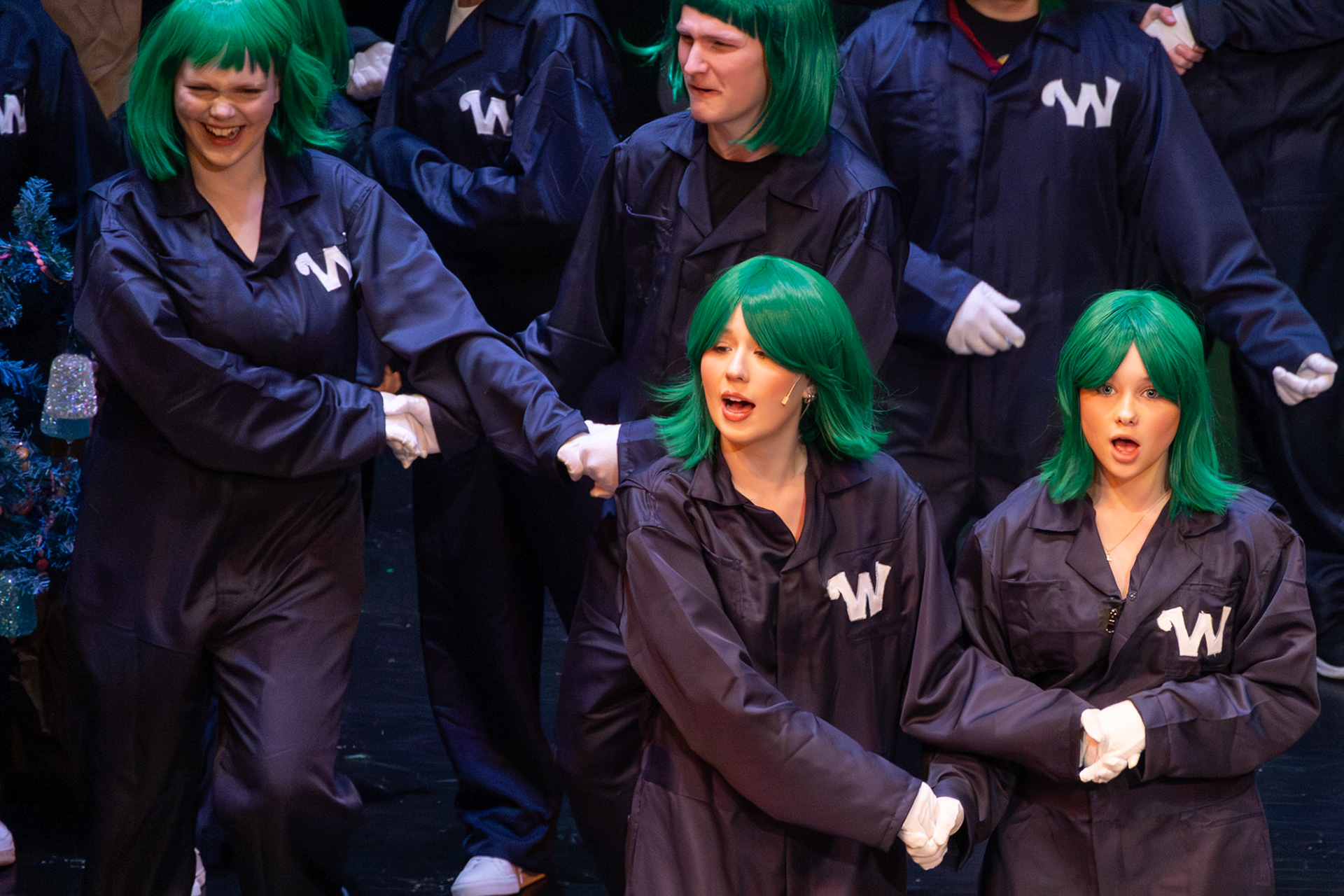 Linked arm in arm, Oompa Loompas sing in perfect harmony, bringing energy and charm to the factory floor. (Photo by Mackenzie Popma)