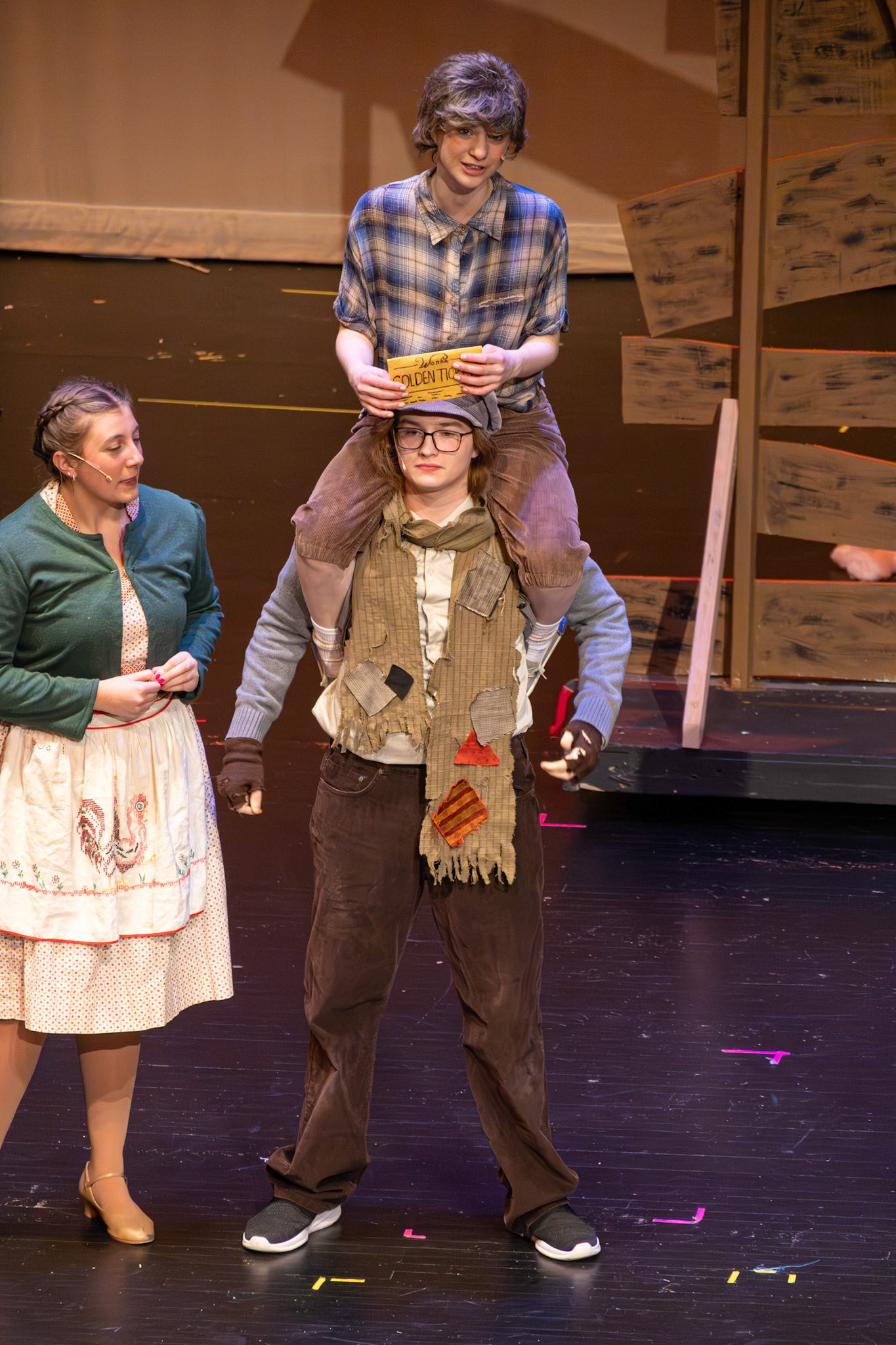 Emma Kellogg’s Charlie rides on his father’s shoulders (played by Owen Williams), celebrating the moment he finds the final golden ticket. (Photo by Mackenzie Popma)