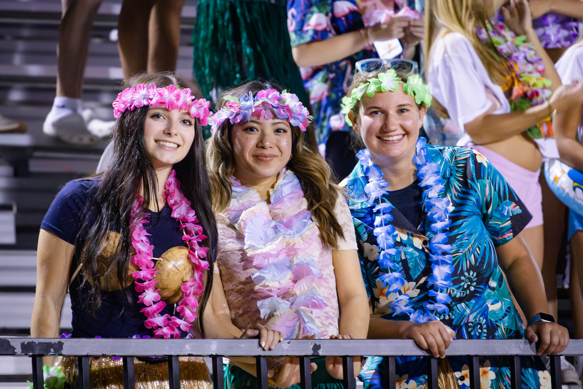 TROPICAL VIBES  Seniors Emily Dark, Chelsea Tran, and Addie Luxford dress up for the theme "Tropical Out" for the football game against East Kentwood. (Photo by Abby Skibinski)
