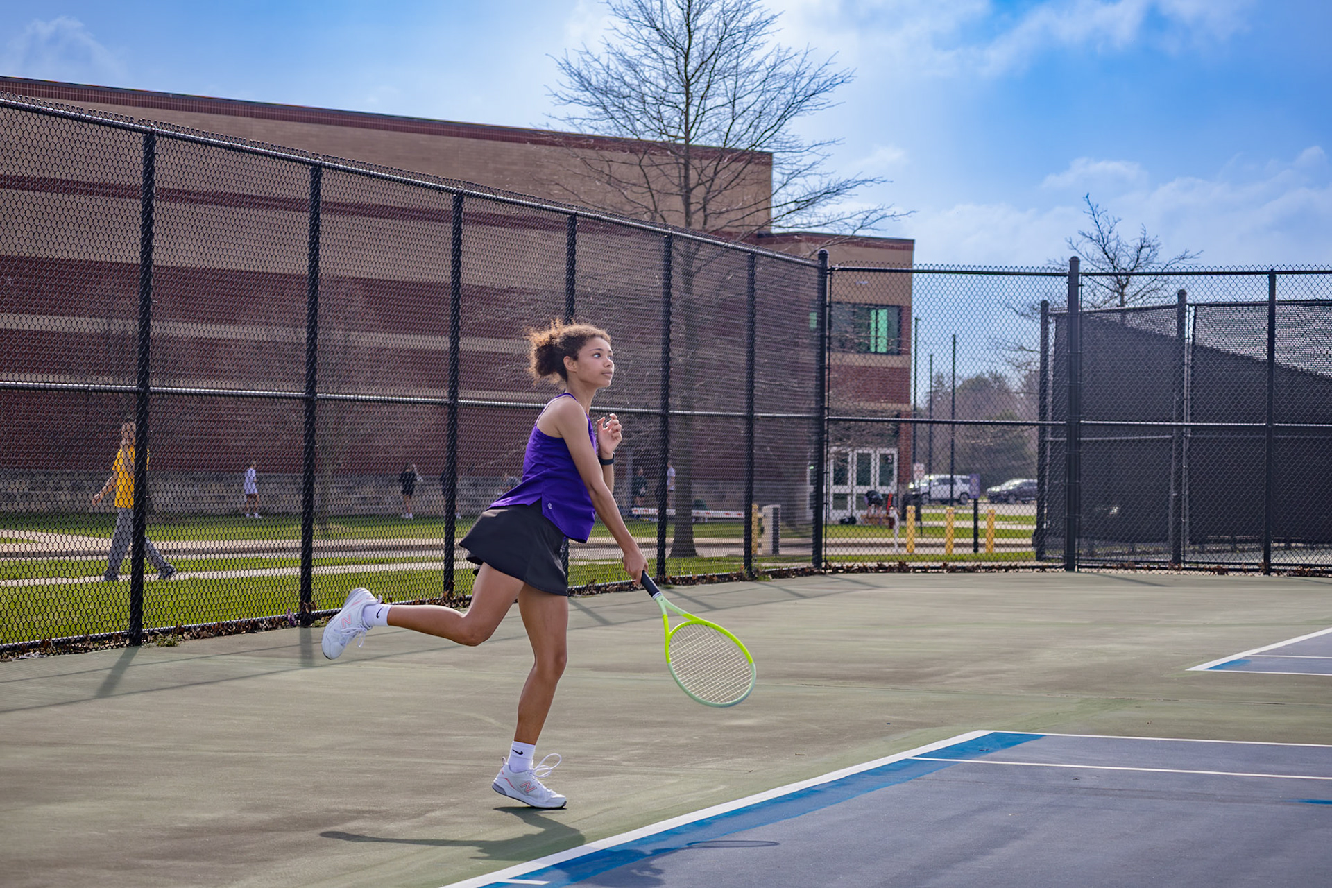 Senior Yelena Wilks prepares to serve against a Mona Shores opponent, her focus set on gaining the next point. (Photo by Abby Skibinski)