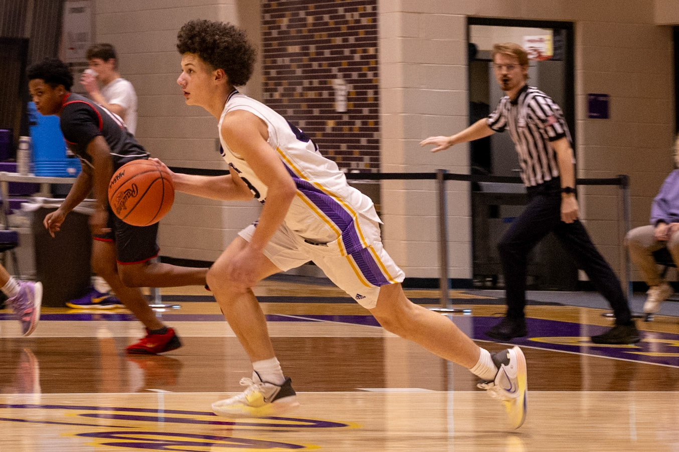 Levell Dunn secures the ball and sprints up the court, pushing the pace as he looks to put points on the board for his team. (Photo by Judah Dorband)