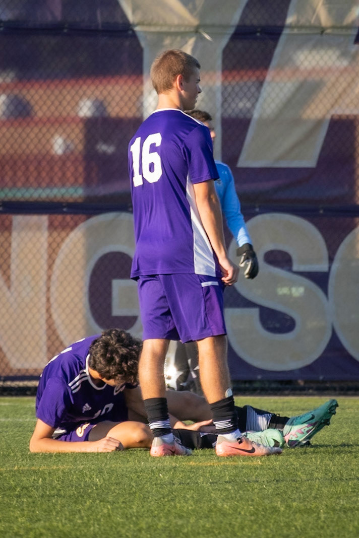 HELPING HANDS  Mason Lapekes checks on Pietro Maestri Mamprin after he rolls his ankle. (Photo by Brianne Weih)