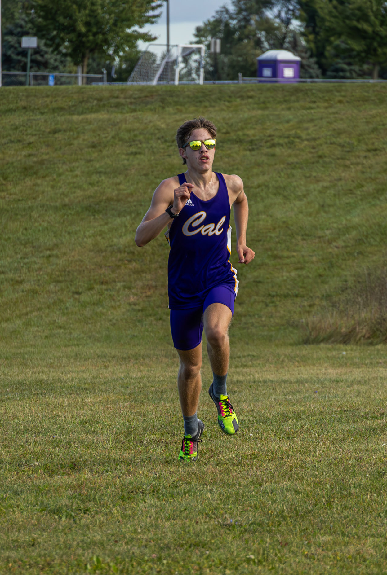 With a powerful final surge, Noah Johnston strides toward the finish in first place, closing out the race with grit and confidence. (Photo by Akaela Daman)