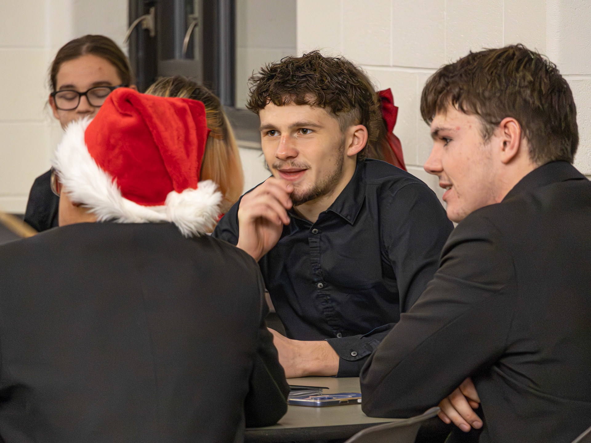 Ben Moss waits with friends, excitement building before their jazz performance at Jazz Band's Auction Night.(Photo By Kayley Martin)