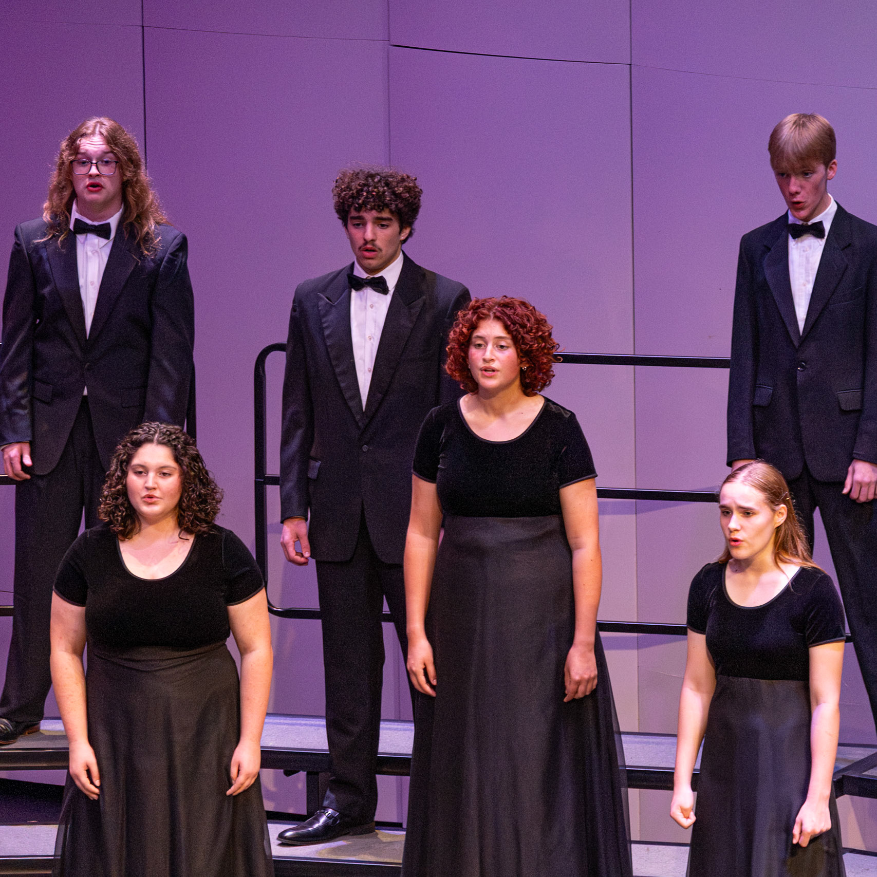 On stage, seniors Malachi Hanson, Christian Moorlag, and Addison Cook join juniors Owen Williams, Ella Rigley, and Abigail Wilkes for a choir concert performance.(Photo by Brianna Severson)