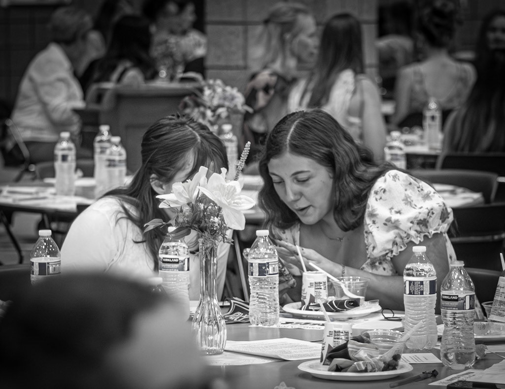 Gabby Linker and Landry Hammond share some photos at the senior Mother-Daughter Breakfast. (Photo by Mariah Peterson)