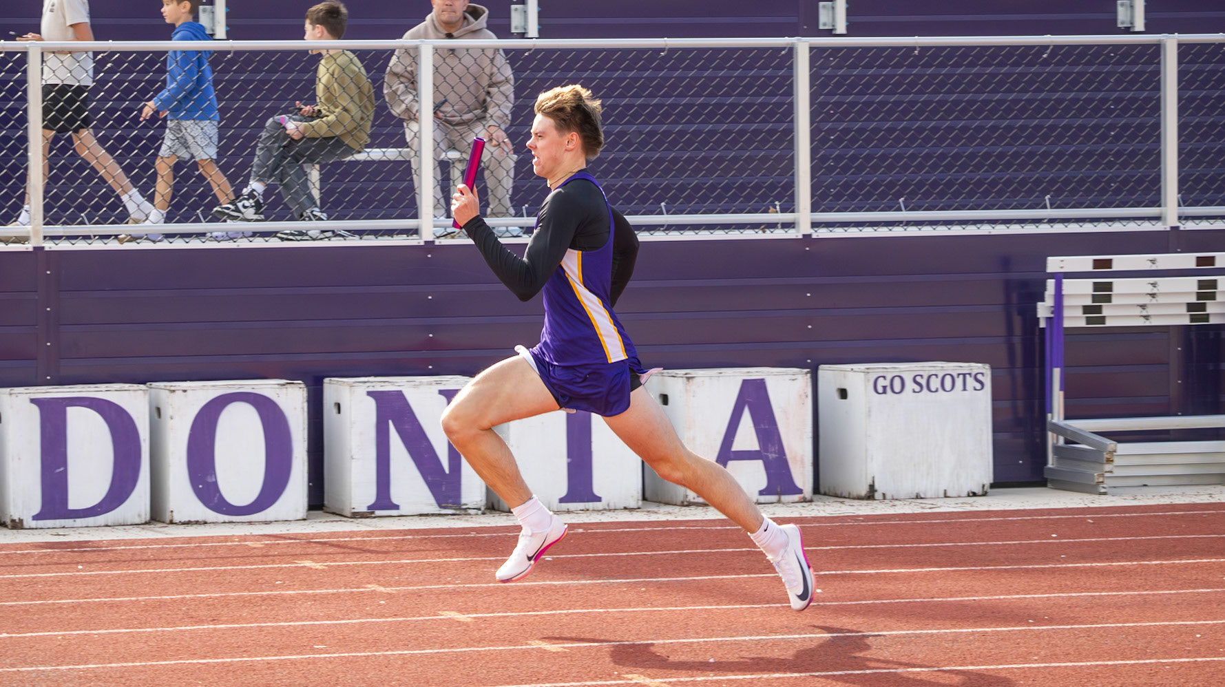 Miles Grengs runs to hand the baton off to his teamate. (Photo by Emma Garza)