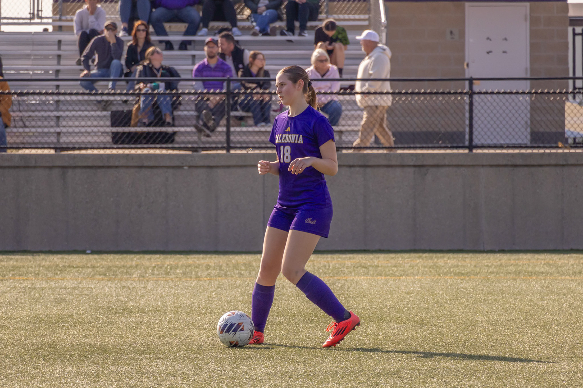 MacKenzi Price scans the field and passes the ball forward to a teammate near the net. (Photo by Ella-Grace Wickens)