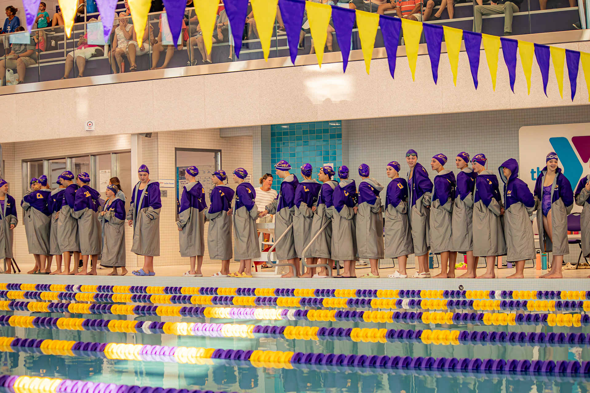 The team stands for the pledge, bracing themselves for the cold water at the Caledonia Community Center. (Photo by Abigail Tava)