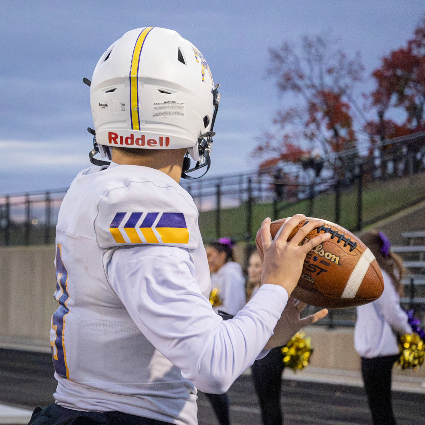 Warming up on the sidelines quarterback Conlan Schultz gets his arm ready for the first play. (Photo by Ella-Grace Wickens)
