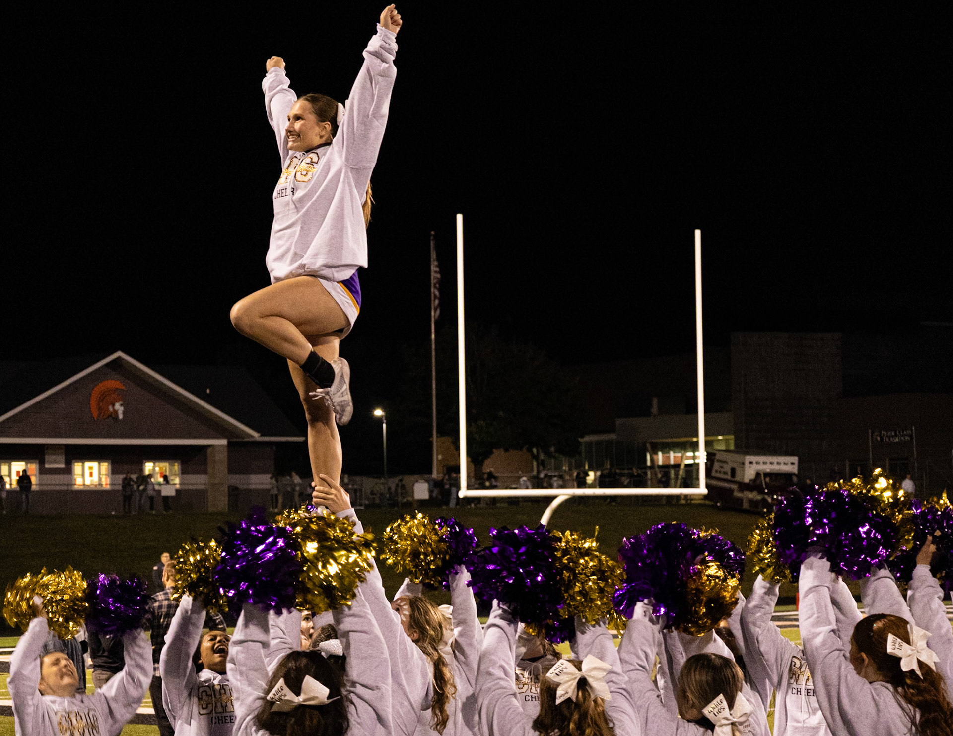 LIFTING SPIRITS HIGH  The cheerleaders support Mariah Peterson in a stunt as she beams Cal Pride. (Photo by Avarey Lippert)