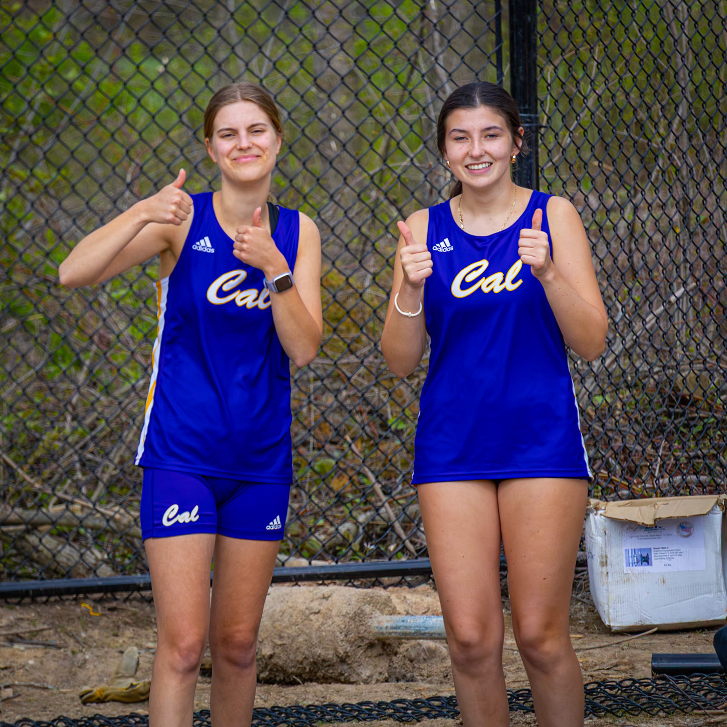 Seniors Sophia Douglass and Ellory Fox give two thumbs up as they wait for their turm to long jump. (Photo by Abigail Douglass)
