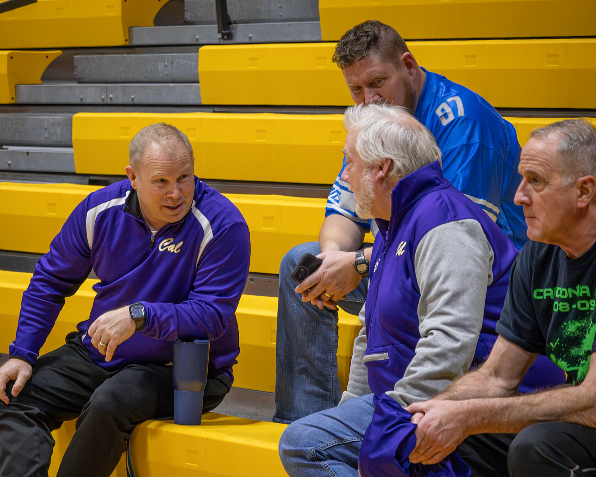 Chatting up in the bleachers Mr. Oster, Mr. Gunnink, and Mr. Knoop can't figure out who's going to win. (Photo by Ella-Grace Wickens)p