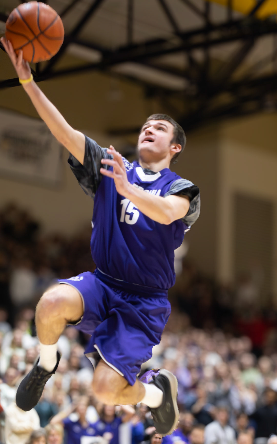 Josh Kietzman leaps into the air, guiding the ball toward the hoop. (Photo by Avarey Lippert)