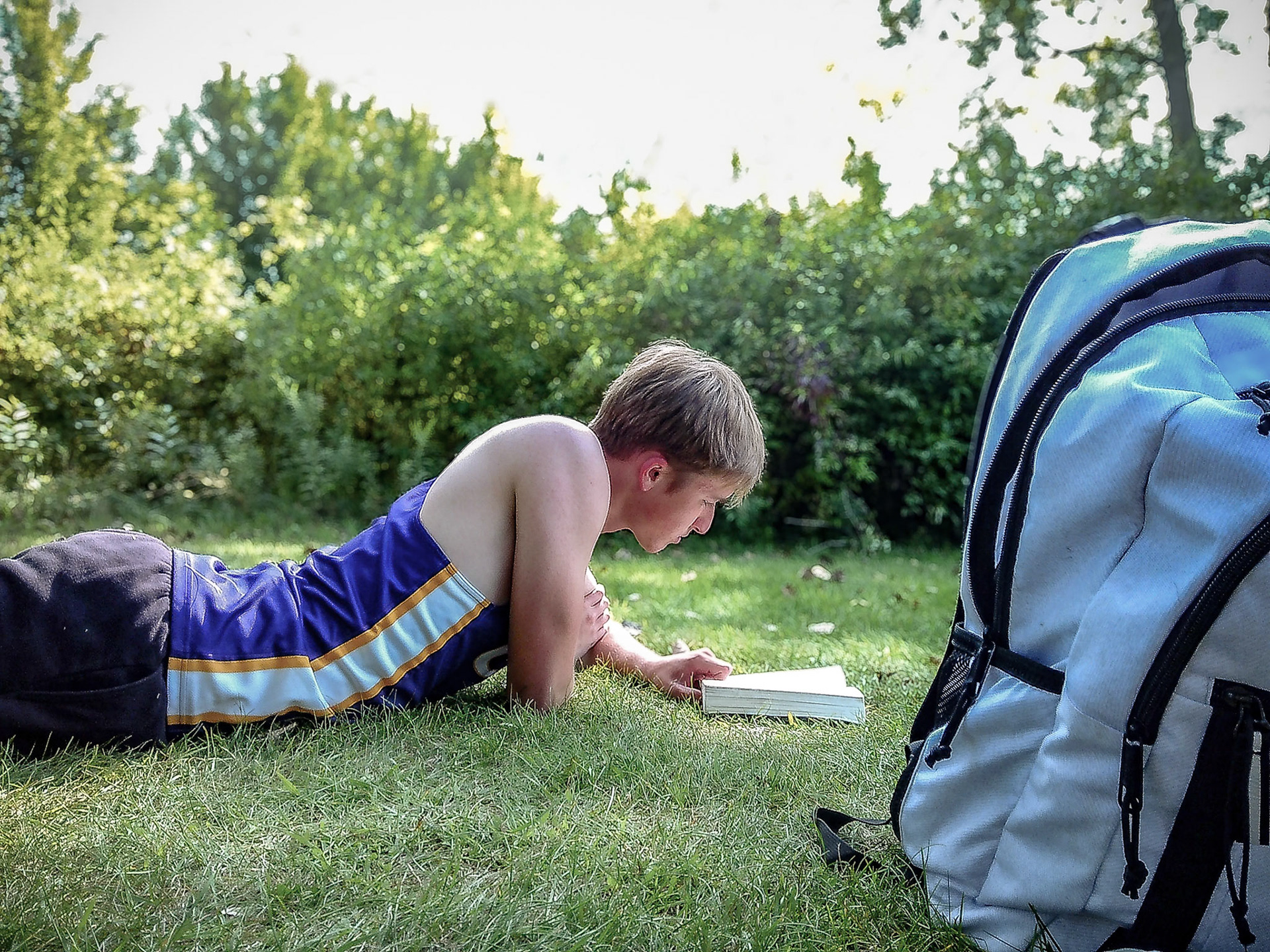 STUDIOUS START  Rydik Wrubel reads before the cross country TK invite—a moment his English teacher mom would surely approve. (Photo by Justin Harper)