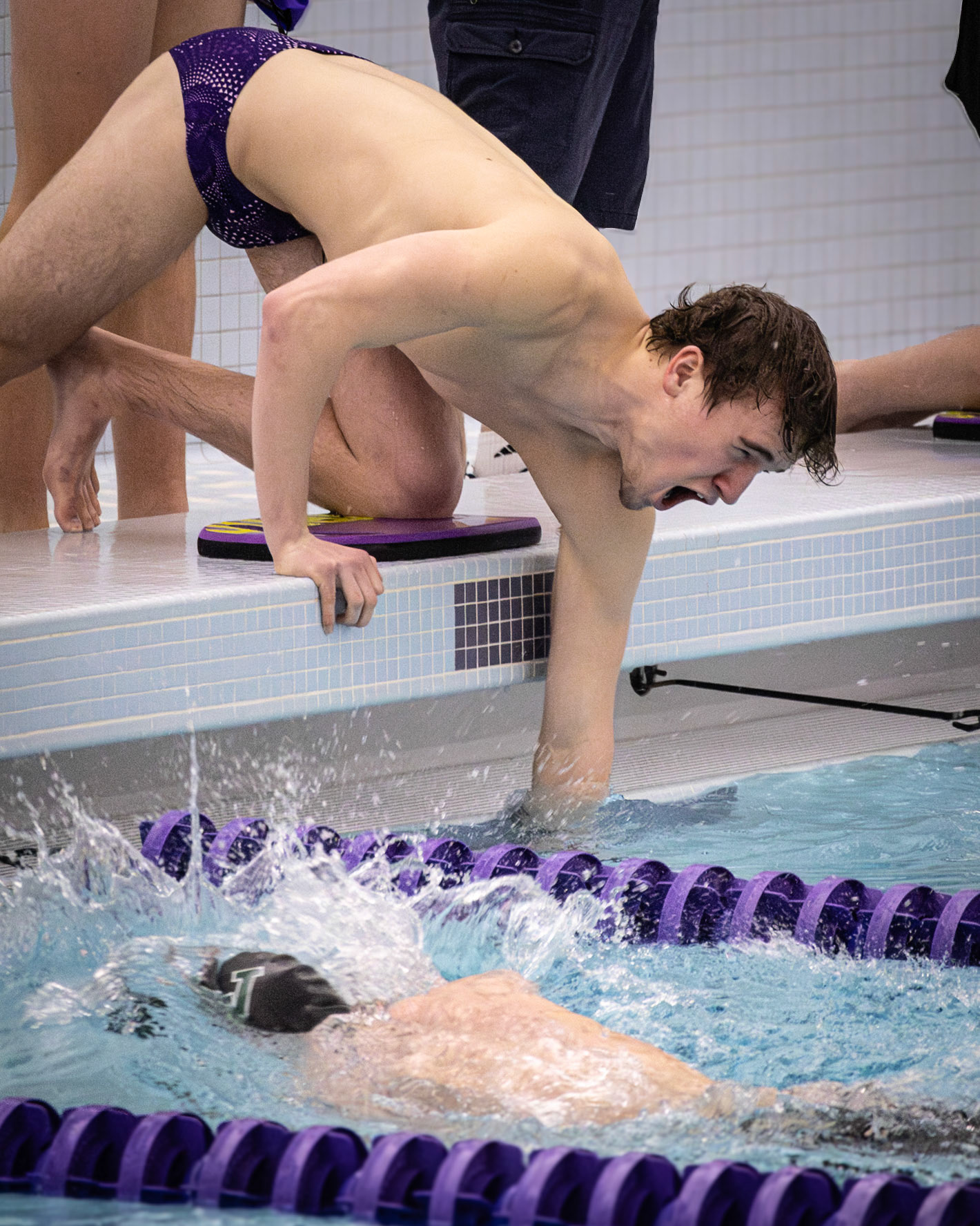 Austin Tufts gives it his all to support his teammate who is current in the water, while counting the twenty nerve-racking laps of the 500-yard freestyle. (Photo by Hailey Thayer)