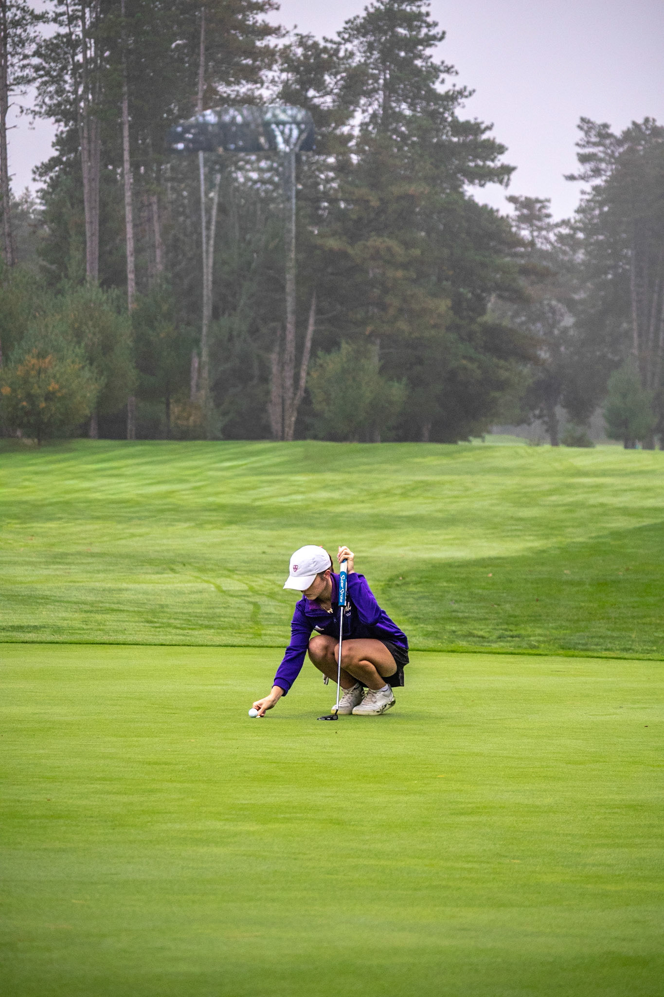 With gray skies overhead, senior Codie O’Krangley lines up her putt. (Photo by Ryder Born)