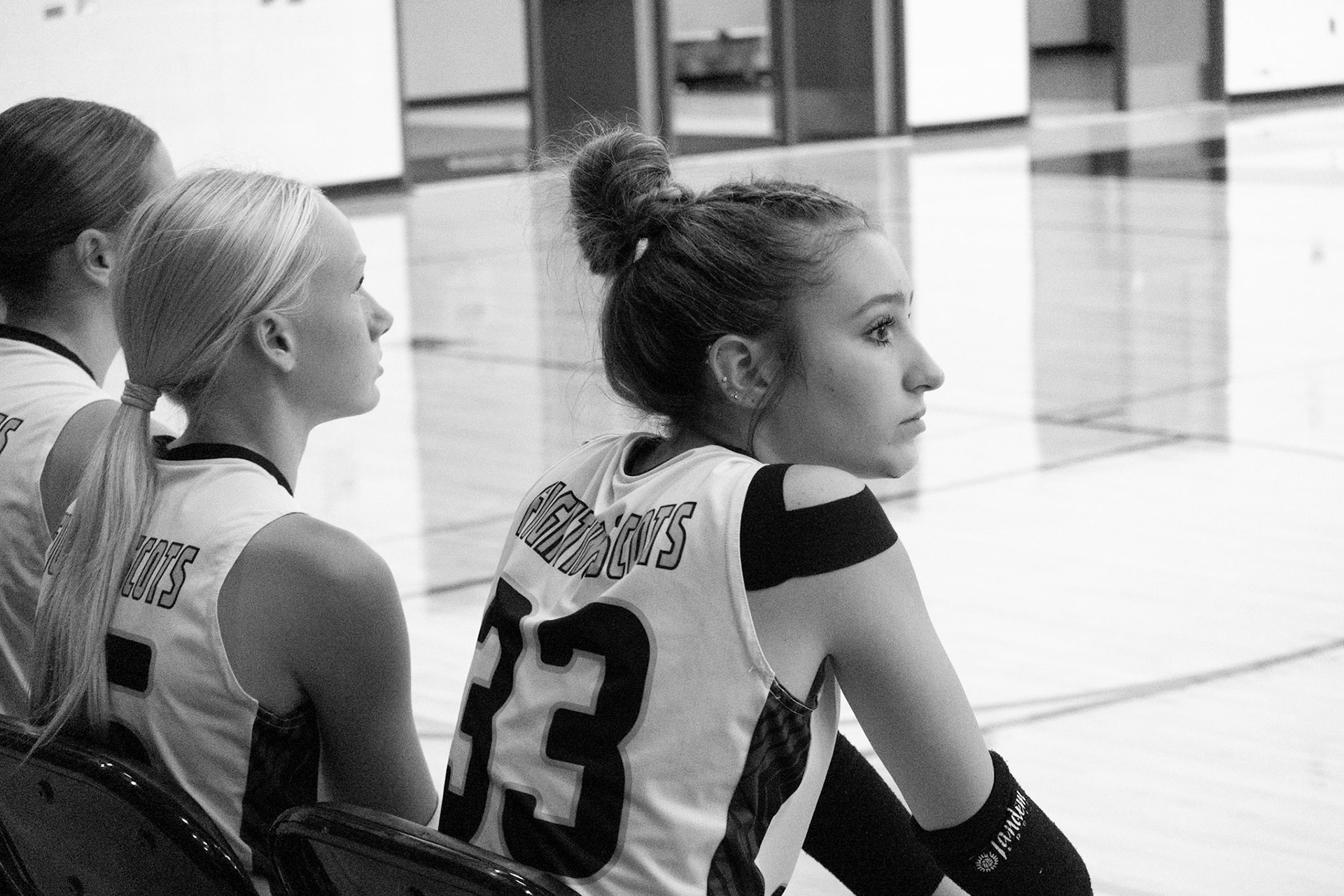 Freshman Maci Warburton sits on the side and watches her team play the play their coach made for them and hoping they get a point! (Photo By Elsha Bytwork)