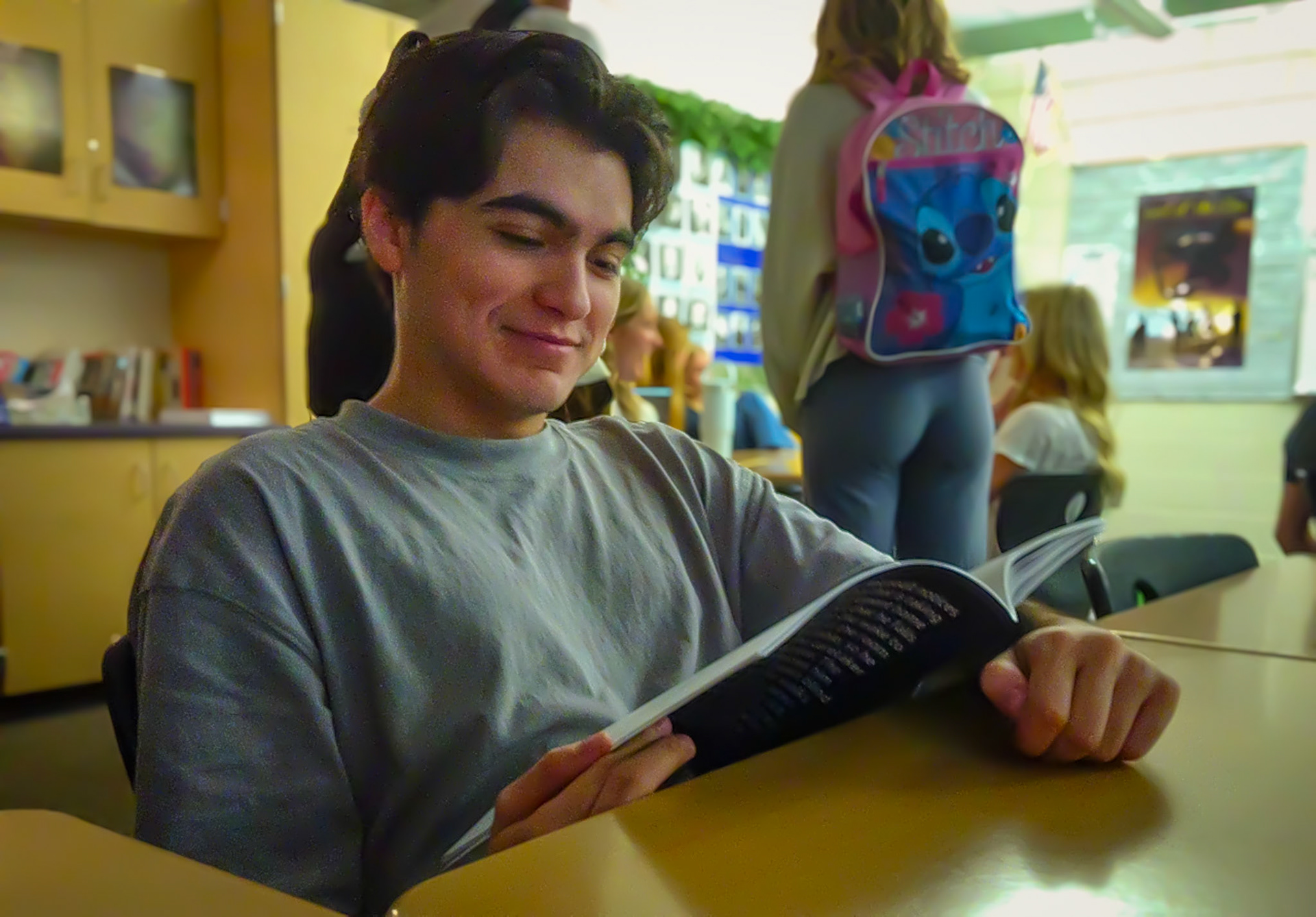 Senior Rian Angeles stays absorbed in his book during creative writing even as the classroom empties around him. (Photo by Molly Larson)