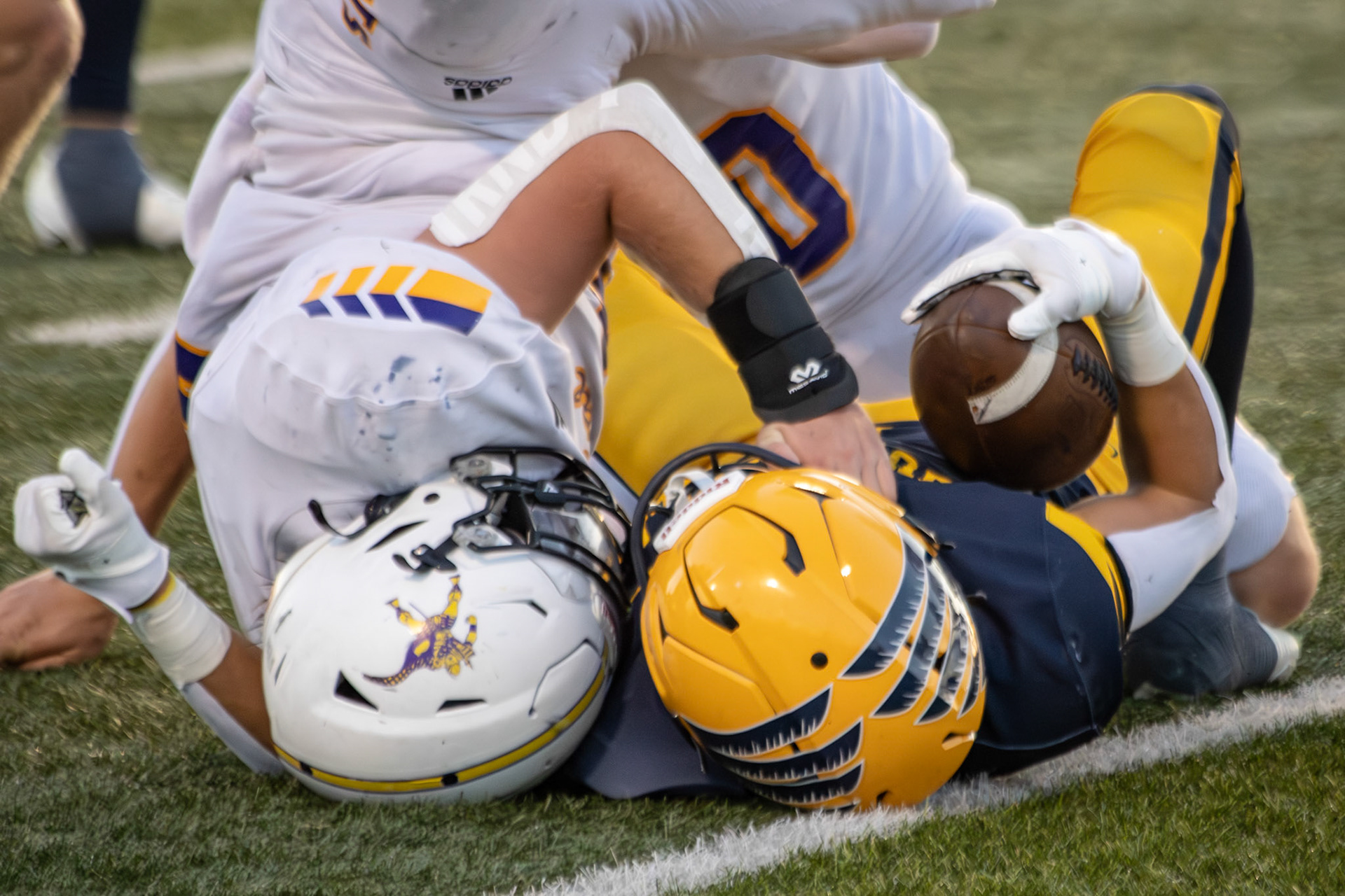 Elliot Clark steps up on defense with a solid tackle, stopping Hudsonville’s play. (Photo by Taya Penoes)