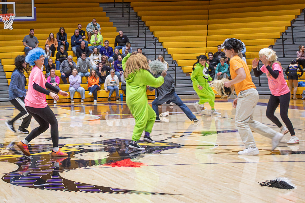 Students run across the floor trying to grab each other’s wigs during a pep assembly game, with the last person wearing one declared the winner. (Photo by Abby Skibinski)