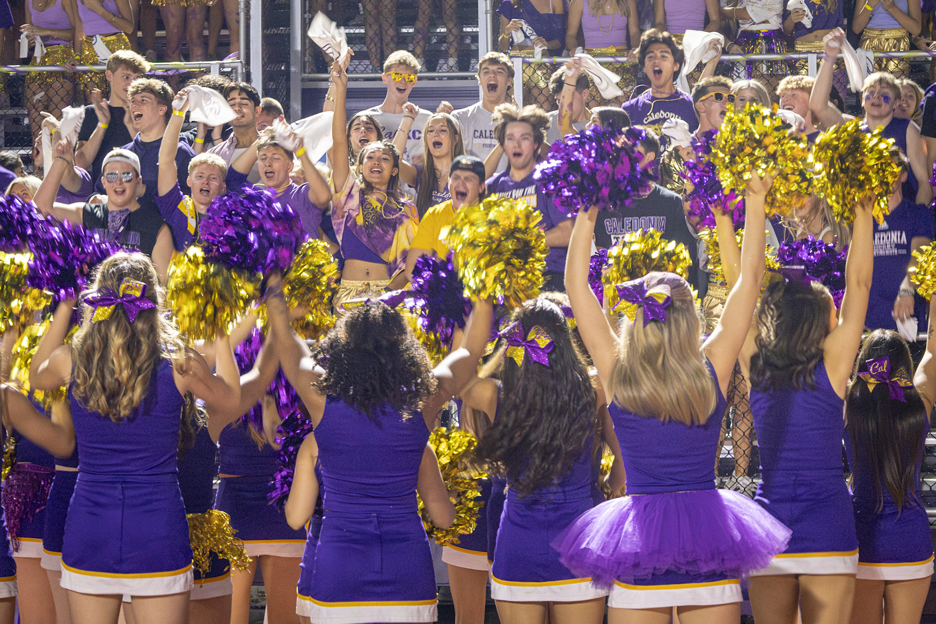The varsity cheerleaders pump up the student section, bringing the energy during the game against Grand Haven. (Photo by Taya Penoes)