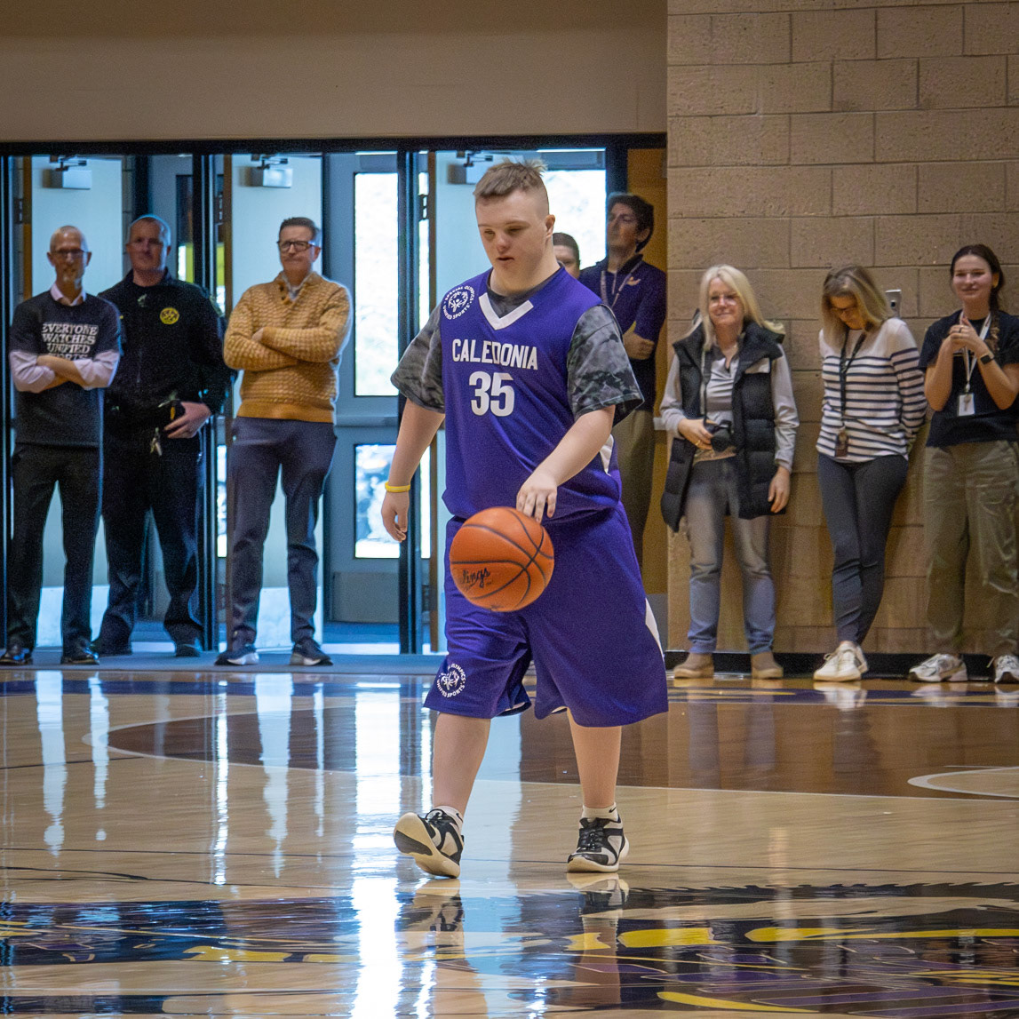 Caleb Helmholdt moves the ball down the court, lining up a shot to contribute to Caledonia’s score. (Photo by Abby Skibinski)