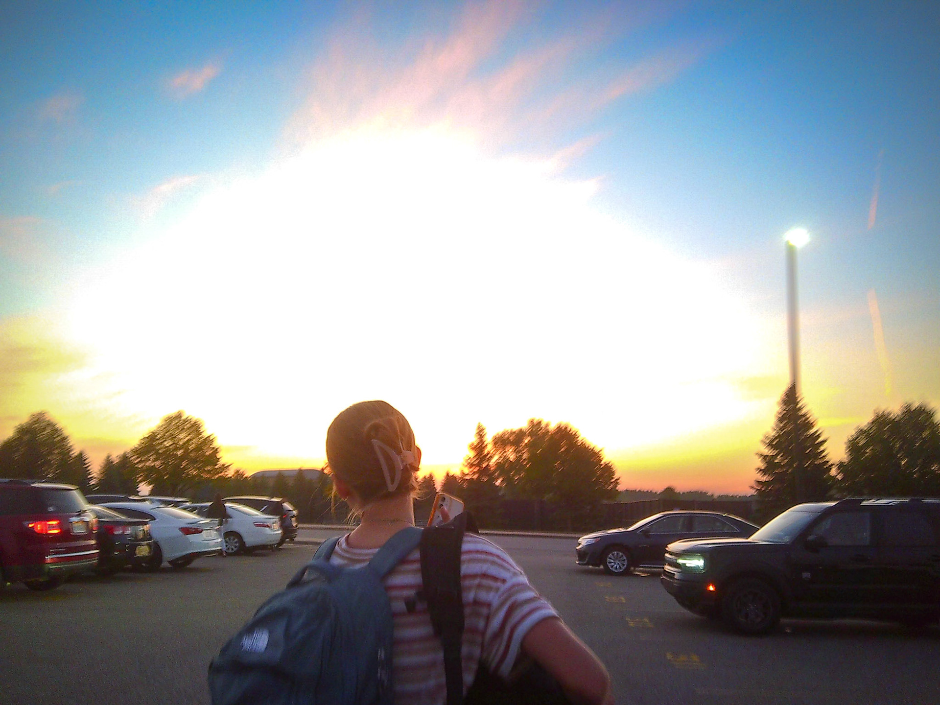 Elise Clarin slowly walks into school but first stops to take in the amazing sunrise behind her. (Photo by Abigail Tava)