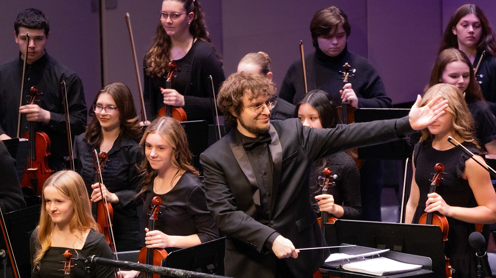 Mr. Liker acknowledges the Freshman Orchestra as applause fills the room with cheer, honoring their months of hard work and a memorable winter performance. (Photo by Caralyn Price)