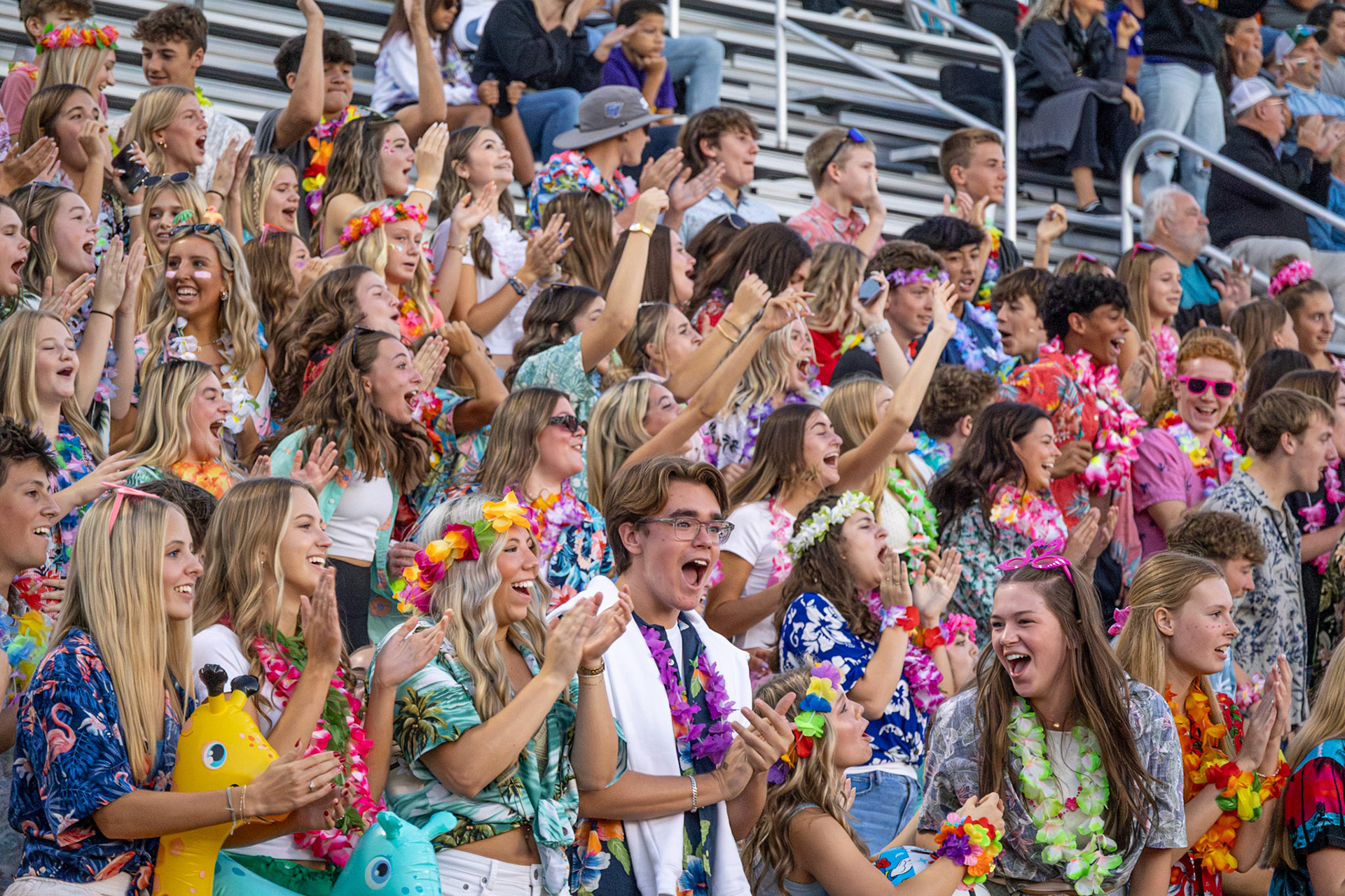 Tropical colors and contagious enthusiasm transforms the football game at East Kentwood into a spirited island escape as students turn to each other celebrating the latest play. (Photo by Avarey Lippert)