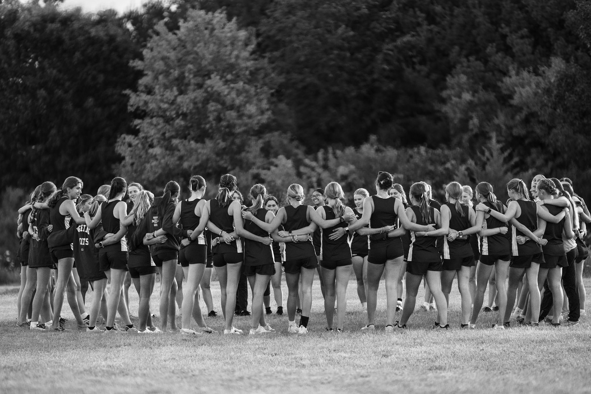 TEAM HUDDLE  The girls’ cross country team gathers before the meet, ready to take on the course. (Photo by Caralyn Price)