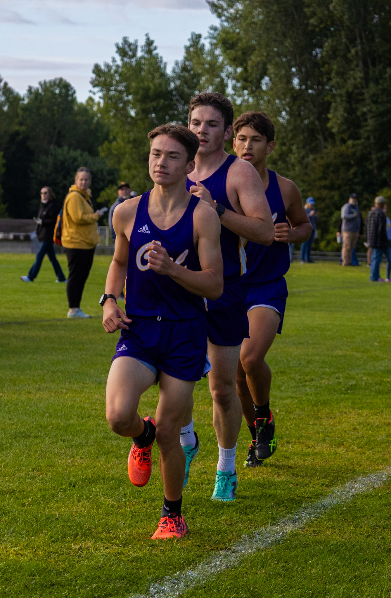 STRENGTH IN STRIDE  Running side by side, the trio keeps pace and pushes each other forward through every mile of the cross country meet. (Photo by Akaela Daman)