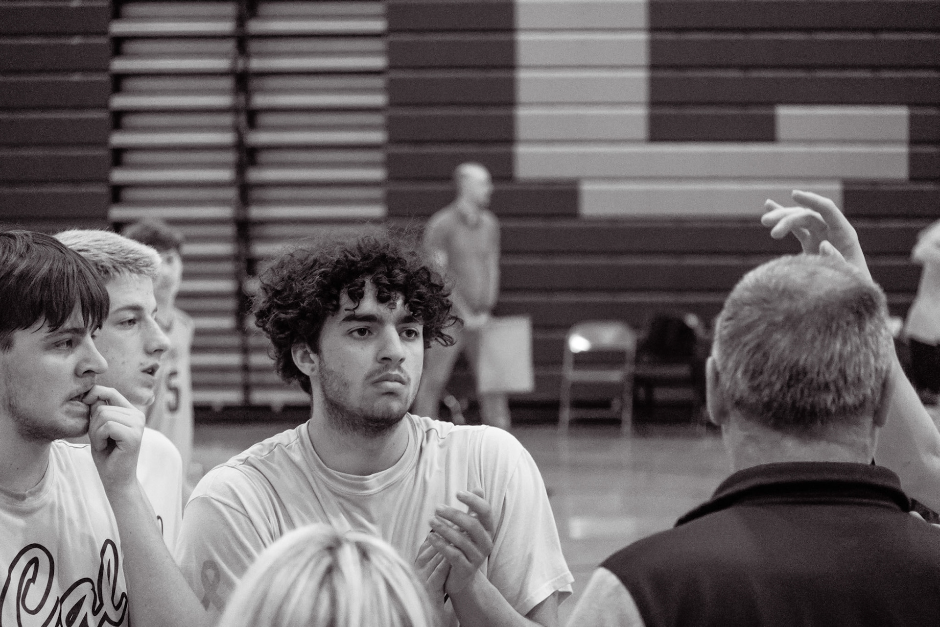 Malachi Hanson and his teammates give their full attention as coach breaks it down, setting the tone for the next play. (Photo by Natalia Teneyuque)