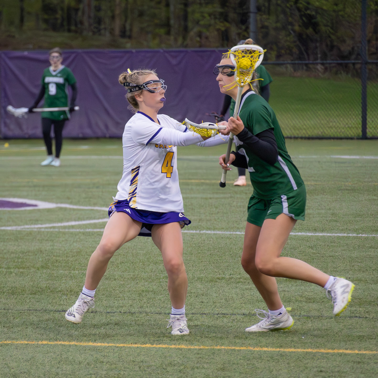 Caelyn Crocker uses strong stick checking to break up the play, preventing the attacker from advancing toward the goal. (Photo by Abby Skibinski)